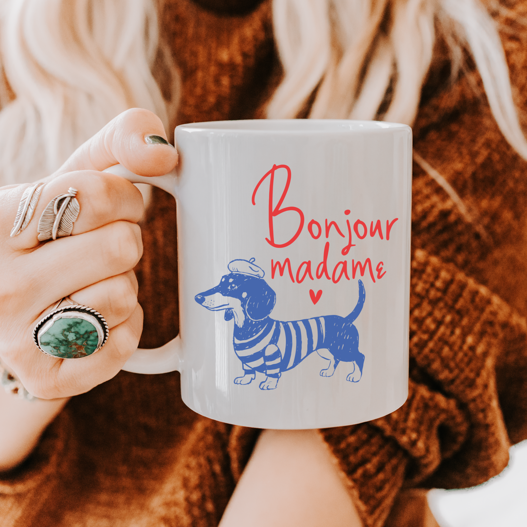 Person holding an 11oz. mug with a dachshund illustration and 'Bonjour madame' text.