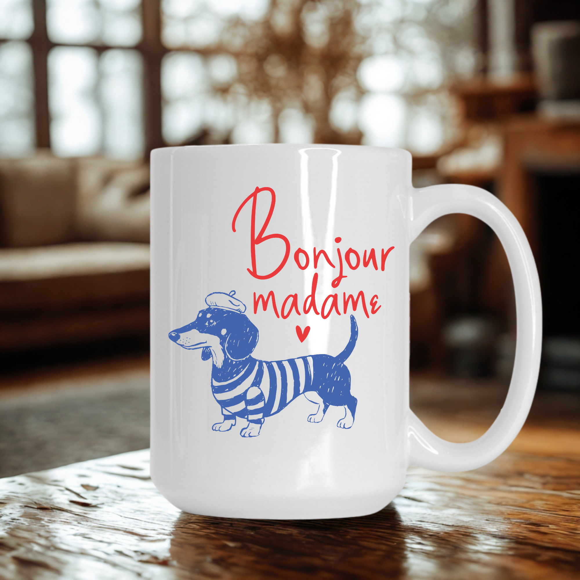 White 15oz. mug with blue dachshund illustration and 'Bonjour madame' text on a wooden table.