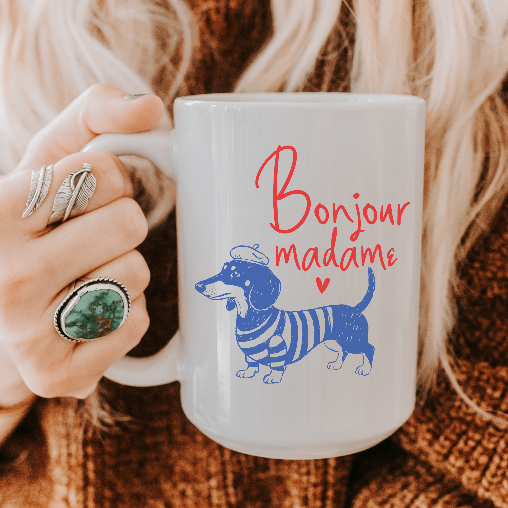 Person holding a 15oz. mug with a dachshund illustration and 'Bonjour madame' text.