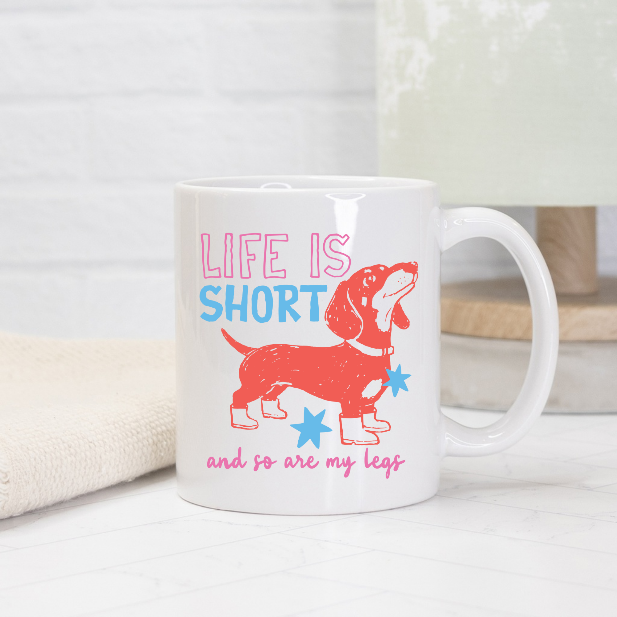 White 11oz. mug with a red dachshund graphic and text 'Life is short and so are my legs' on a light background.