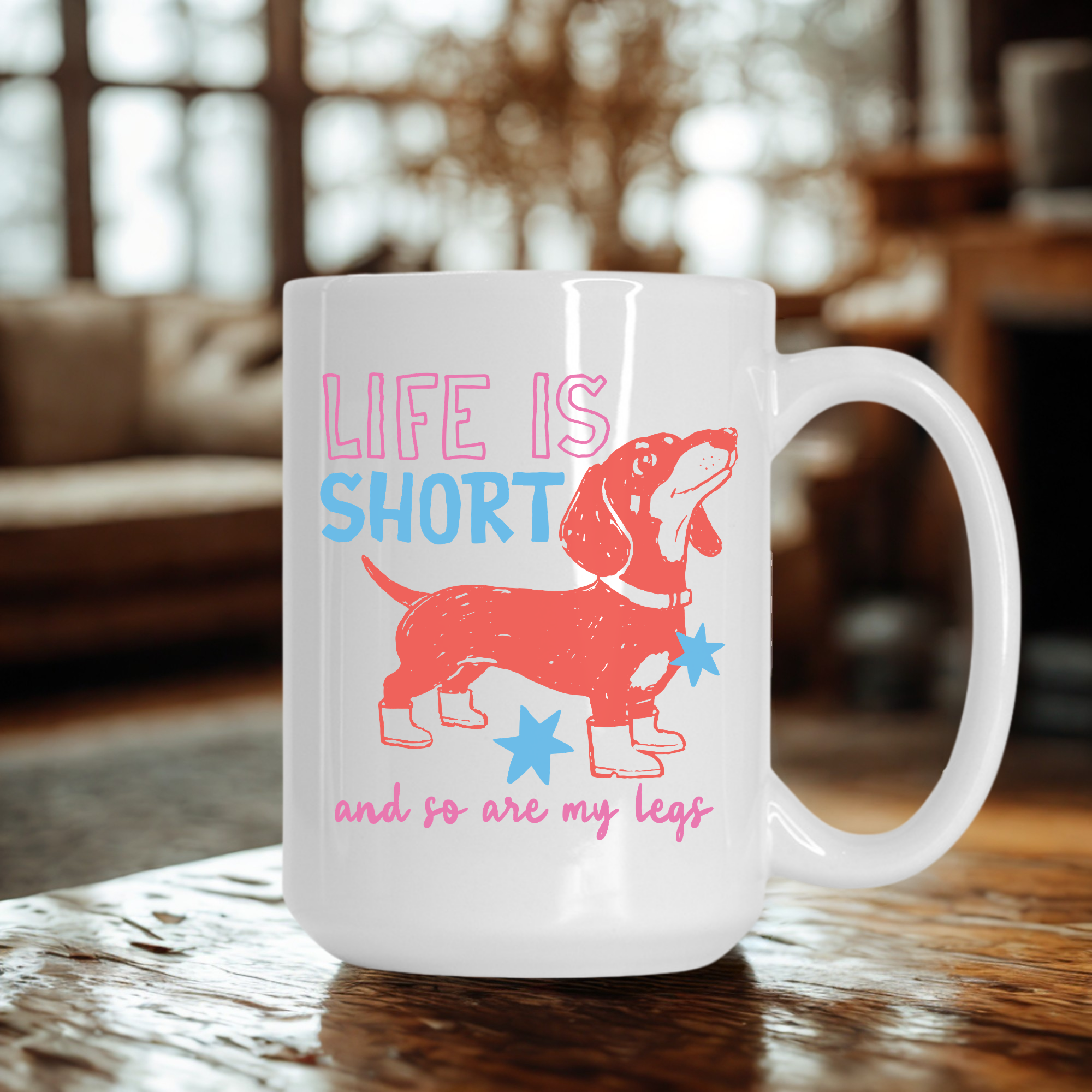 White 15oz. mug with a dachshund design and text 'Life is short and so are my legs' on a wooden table.
