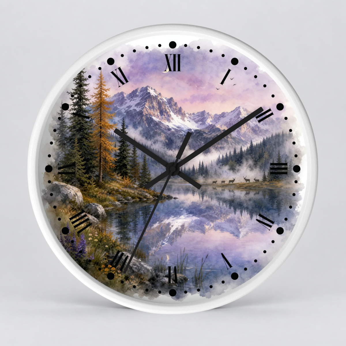 Round wall clock with a scenic mountain lake landscape with a herd of deer at dusk printed on the face, black Roman numerals, and black clock hands on a white rim, shown against a light gray background.