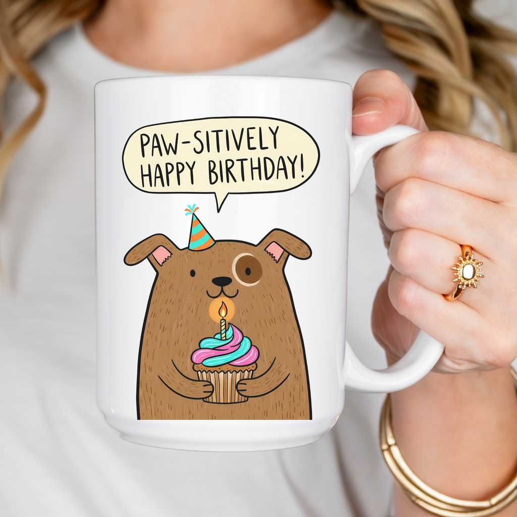 Mug with cartoon dog holding a birthday cupcake and 'Paw-sitively Happy Birthday!' text.