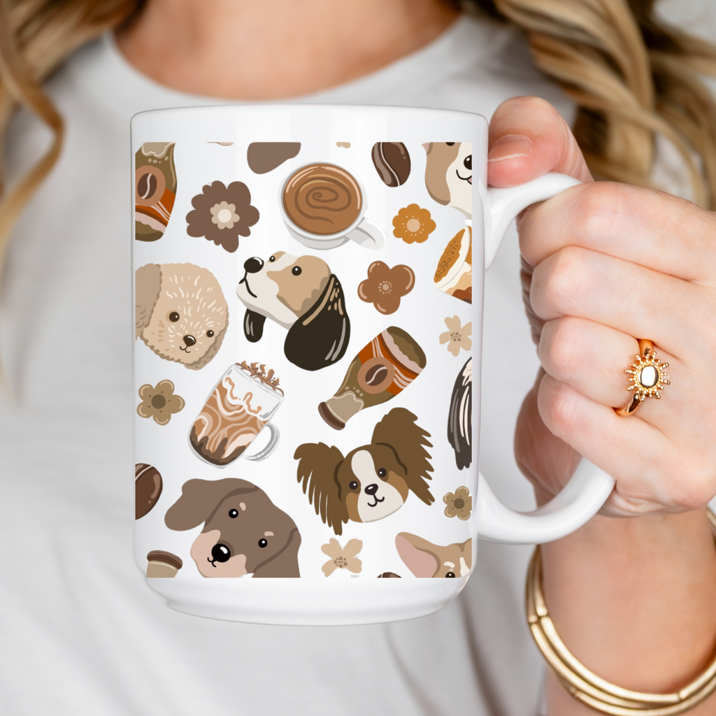 Person holding a white mug with dog and coffee pattern