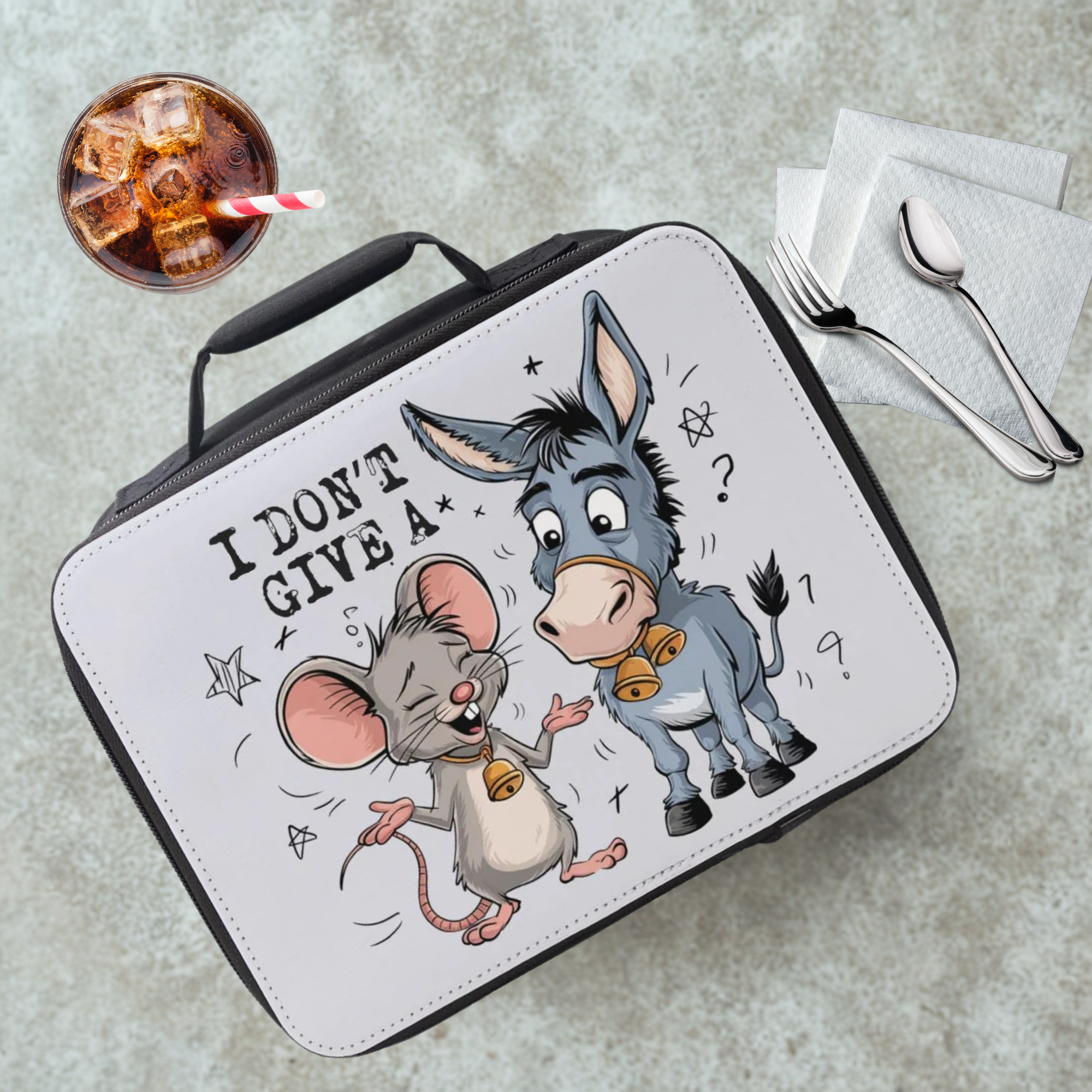 Lunch box with cartoon mouse and donkey design on a gray surface with a drink and utensils.