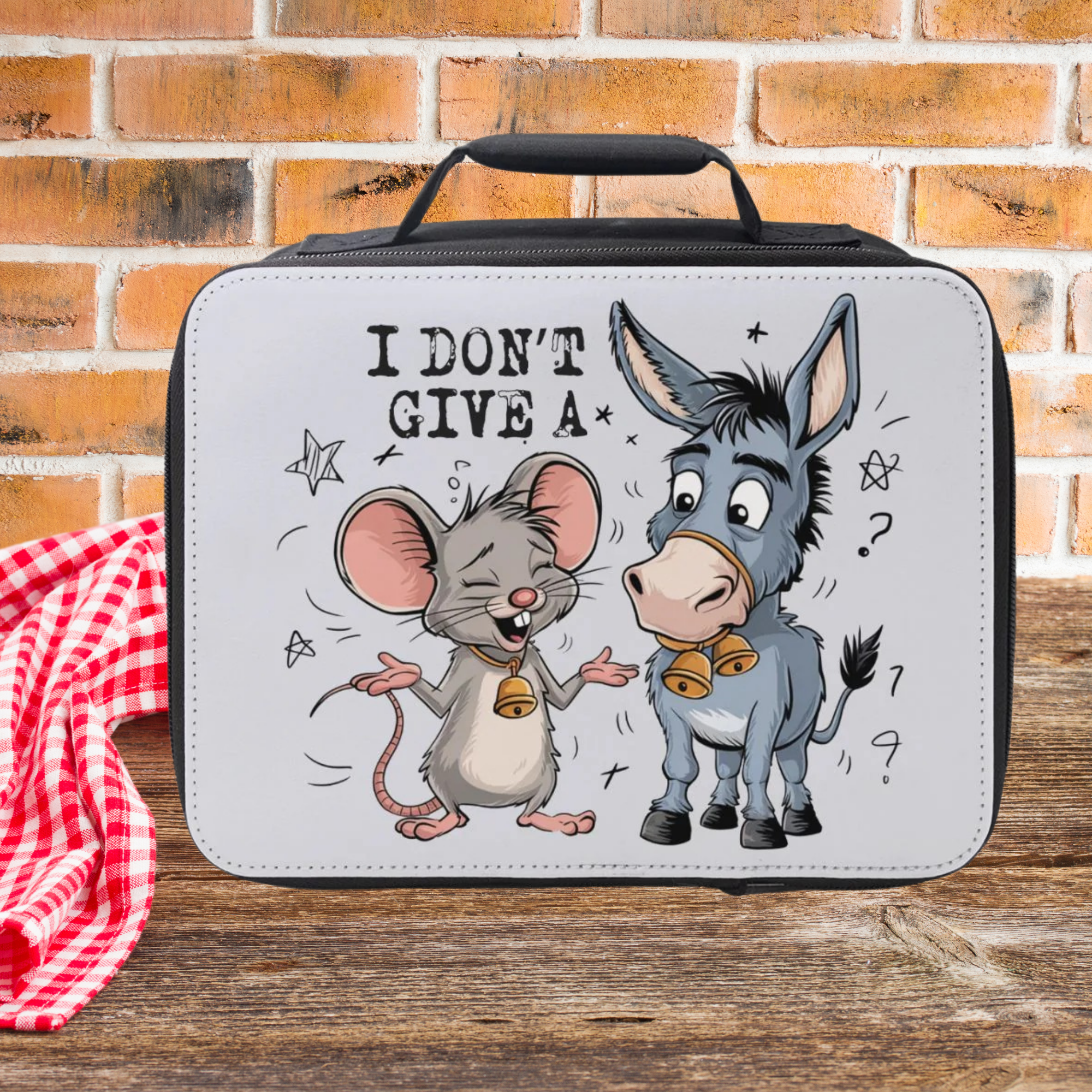 Lunch bag with cartoon mouse and donkey design on a wooden picnic table against a brick wall background