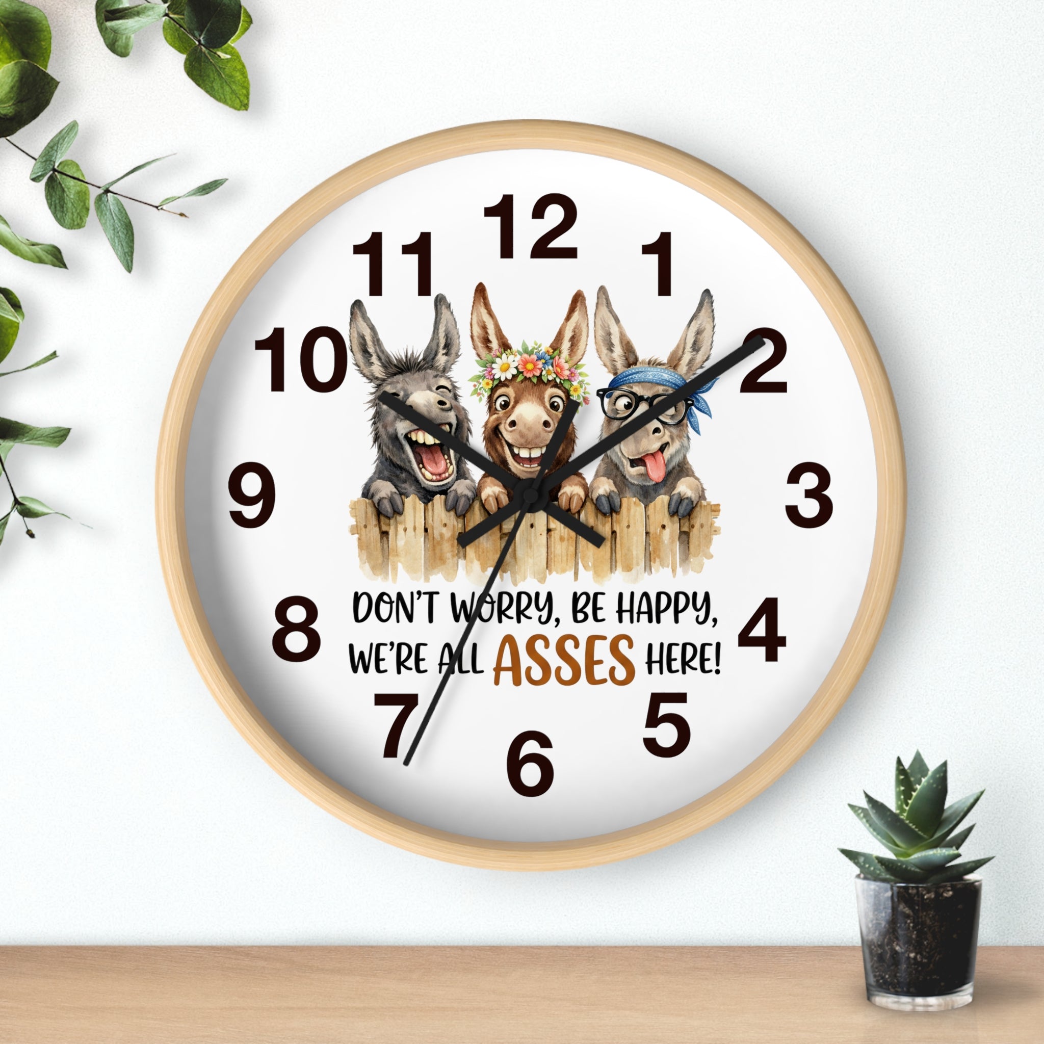 Wall clock with cartoon donkeys and humorous text on a white background