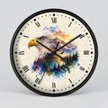 A round wall clock with a black frame and Roman numerals, featuring a printed design of an eagle head layered over a colorful landscape of mountains, lake, and trees on an off-white background.