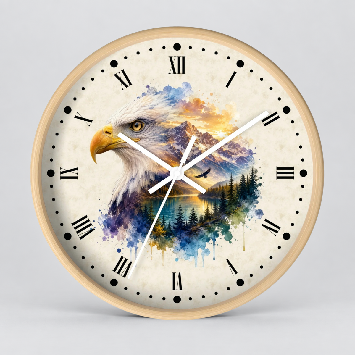 A round wall clock with a light wood frame and a detailed watercolor-style print of an eagle over a mountain and forest landscape. The clock face is off-white with black Roman numerals and hands, shown against a neutral gray background.