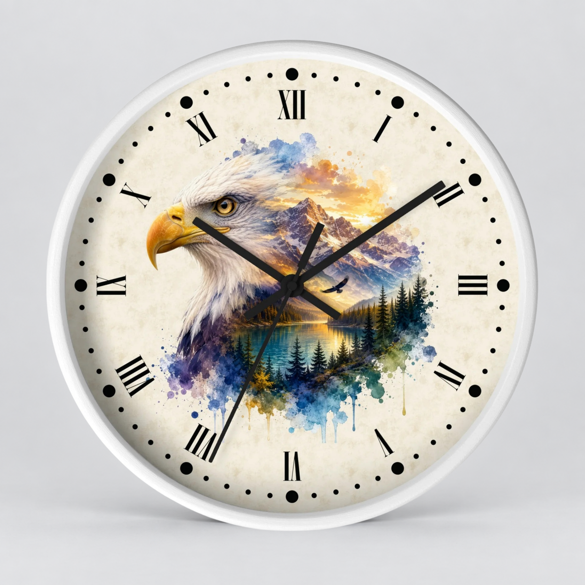 A round wall clock with a white frame and a cream-colored face featuring a watercolor-style design of an eagle over mountains and a forest. The clock has black Roman numerals and black hands, photographed against a neutral light gray background.