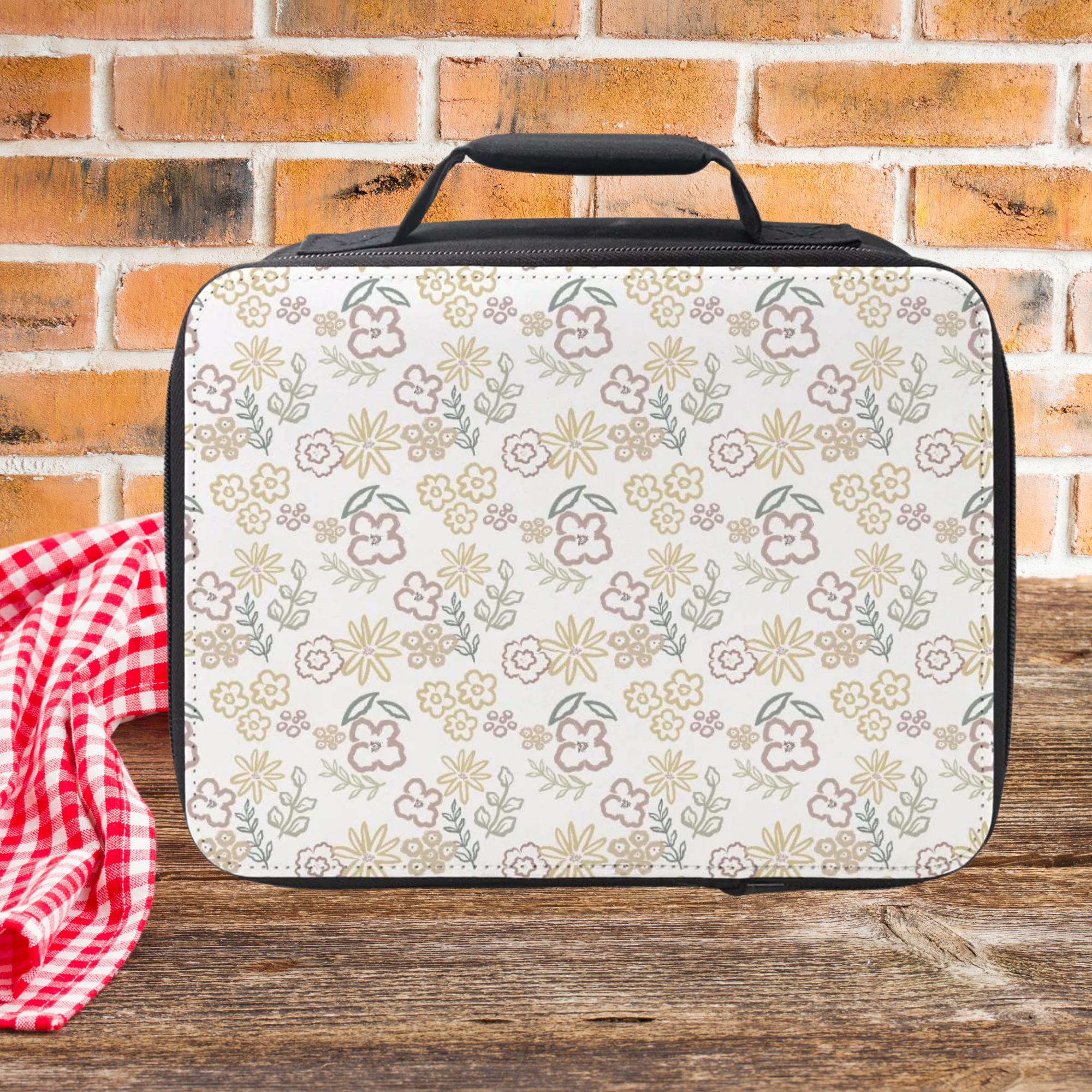 Floral-patterned lunch bag on a wooden picnic table with a brick wall background