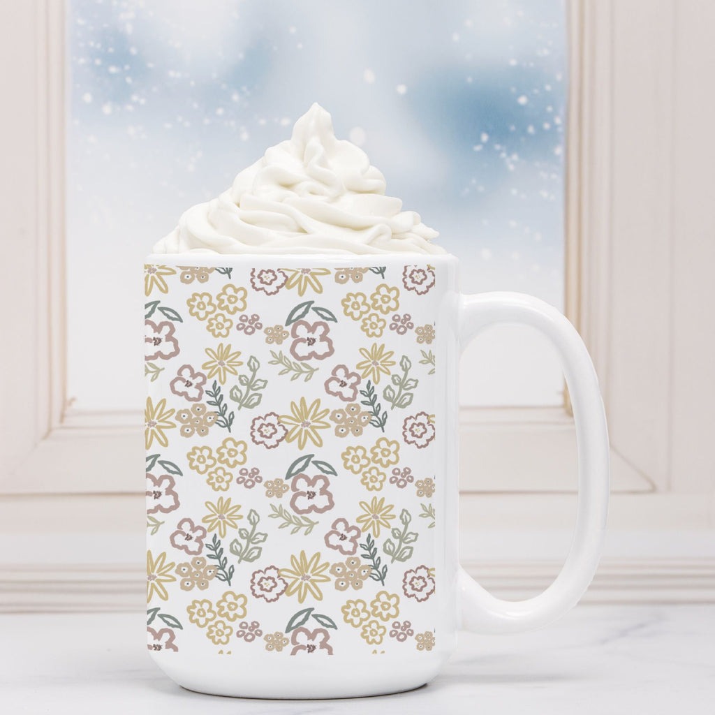 White mug with floral pattern filled with hot chocolate and whipped cream, against a snowy window background.
