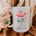 Person holding a 15oz mug with a floral design and text on a textured surface