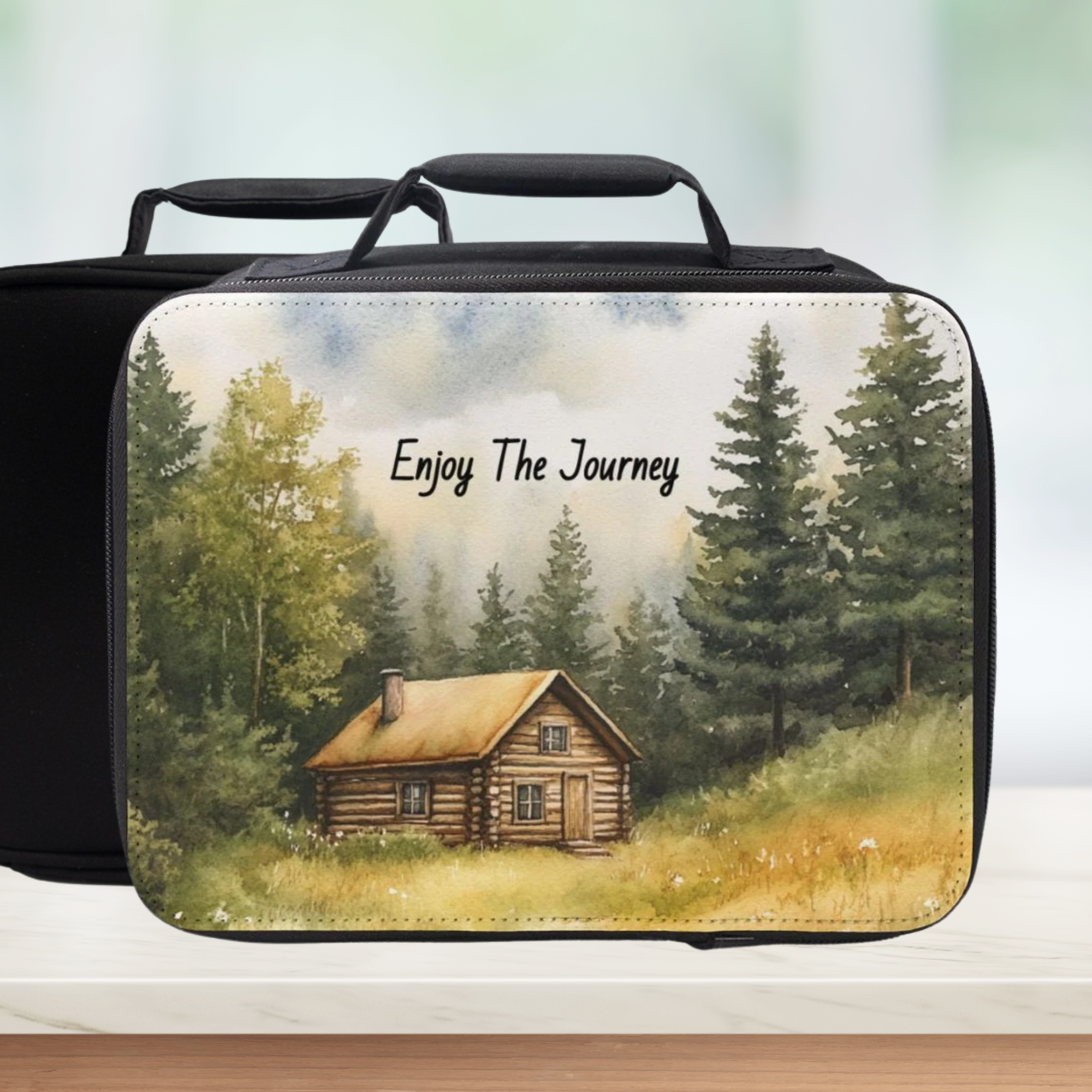 Black lunch bag with a cabin in the woods design and 'Enjoy The Journey' text.