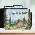 Black lunch bag with a cabin and forest design and 'Escape to the Wild' text on a kitchen counter.