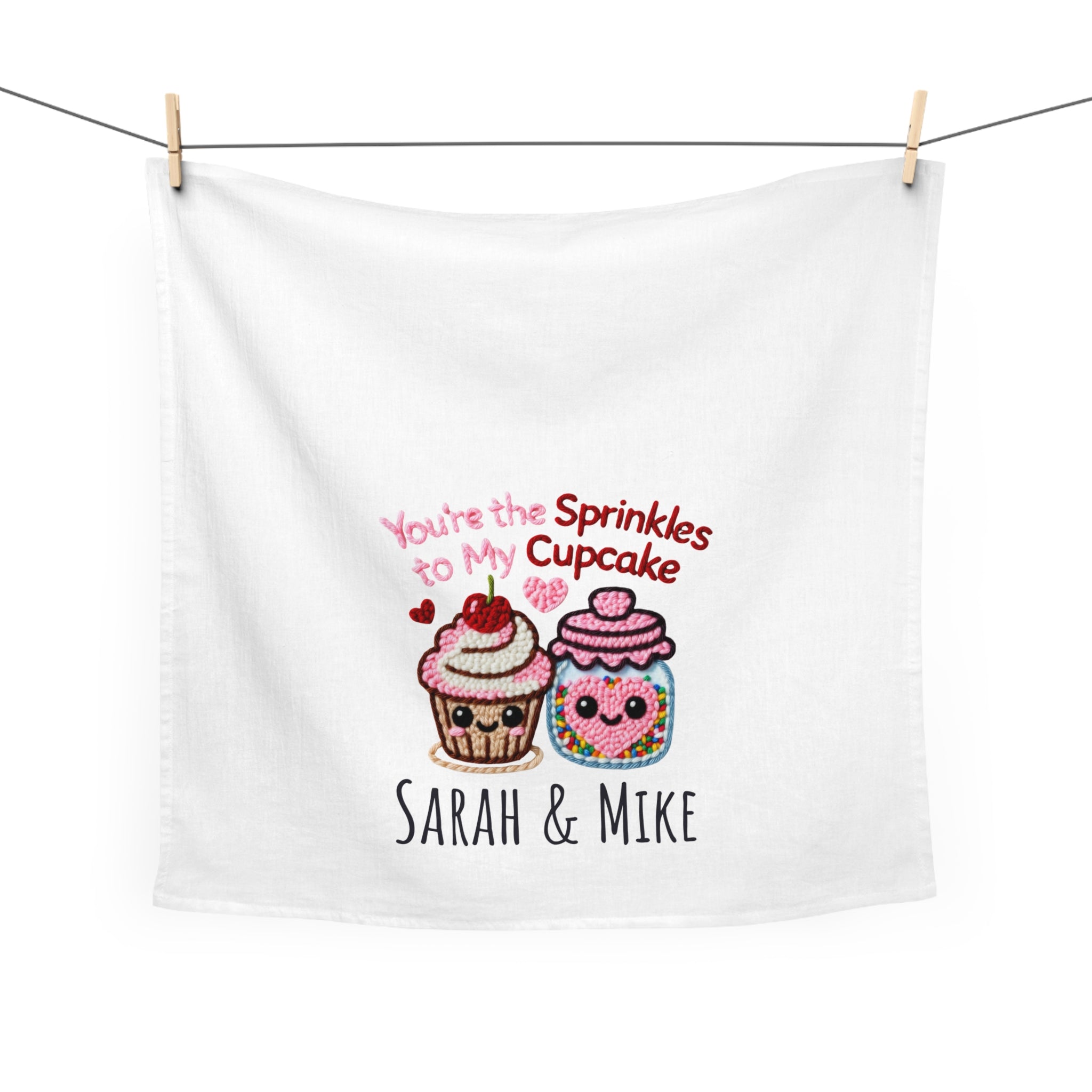 White tea towel with cartoon cupcake and jar design, text 'You're the Sprinkles to my Cupcake' and names 'Sarah & Mike'.