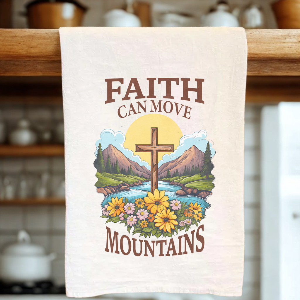 Tea towel with a cross and nature design, featuring the text 'Faith can move mountains', hanging on a wooden rack.