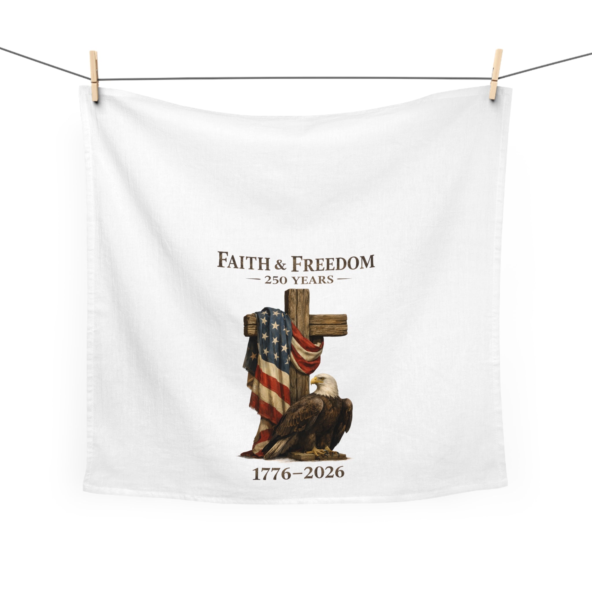 White towel with 'Faith & Freedom' design featuring an eagle, cross, and American flag hanging on a white background.