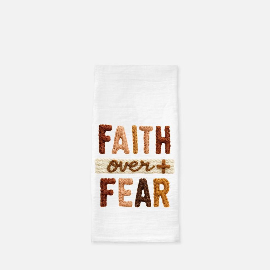 Folded tea towel with the knitted design Text 'FAITH OVER FEAR' on a white background