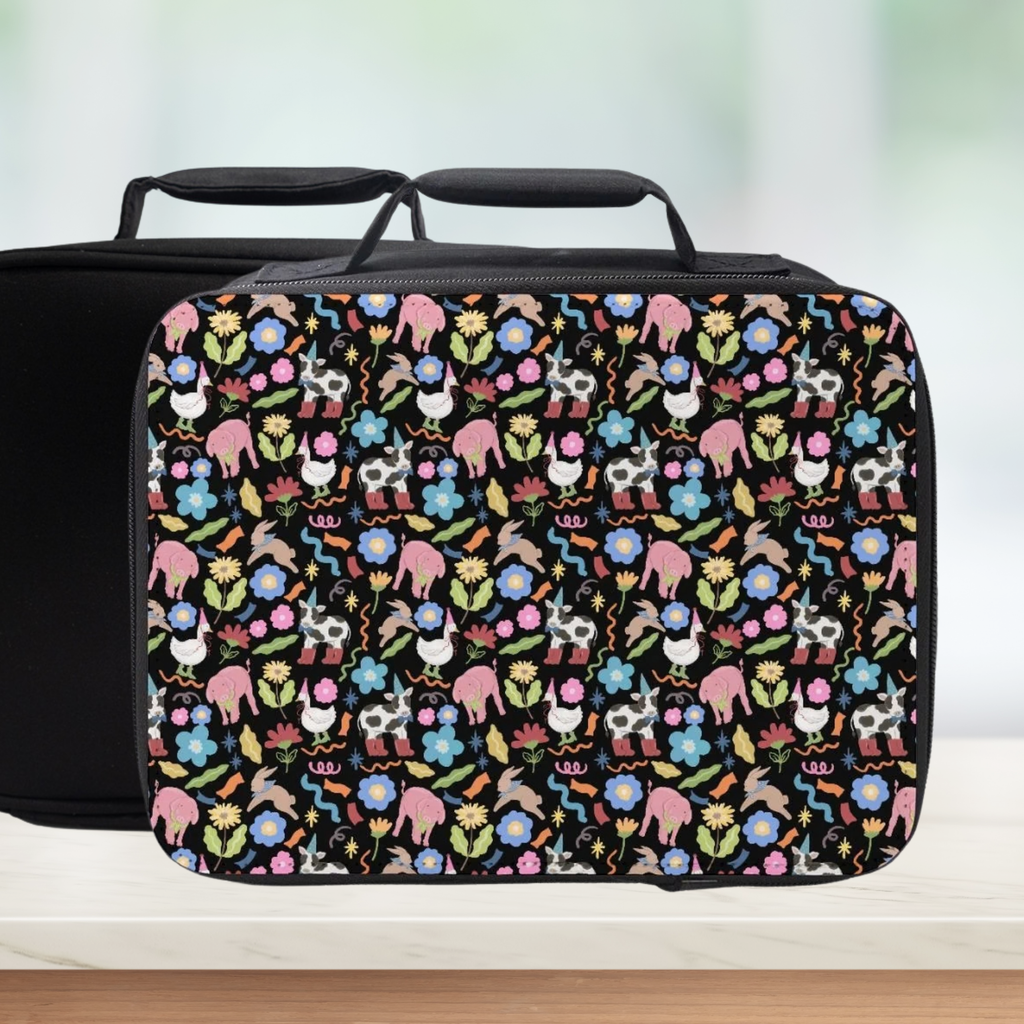 Black lunch bag with colorful farm animals and flower pattern on a white background