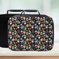Black lunch bag with colorful farm animals and flower pattern on a white background