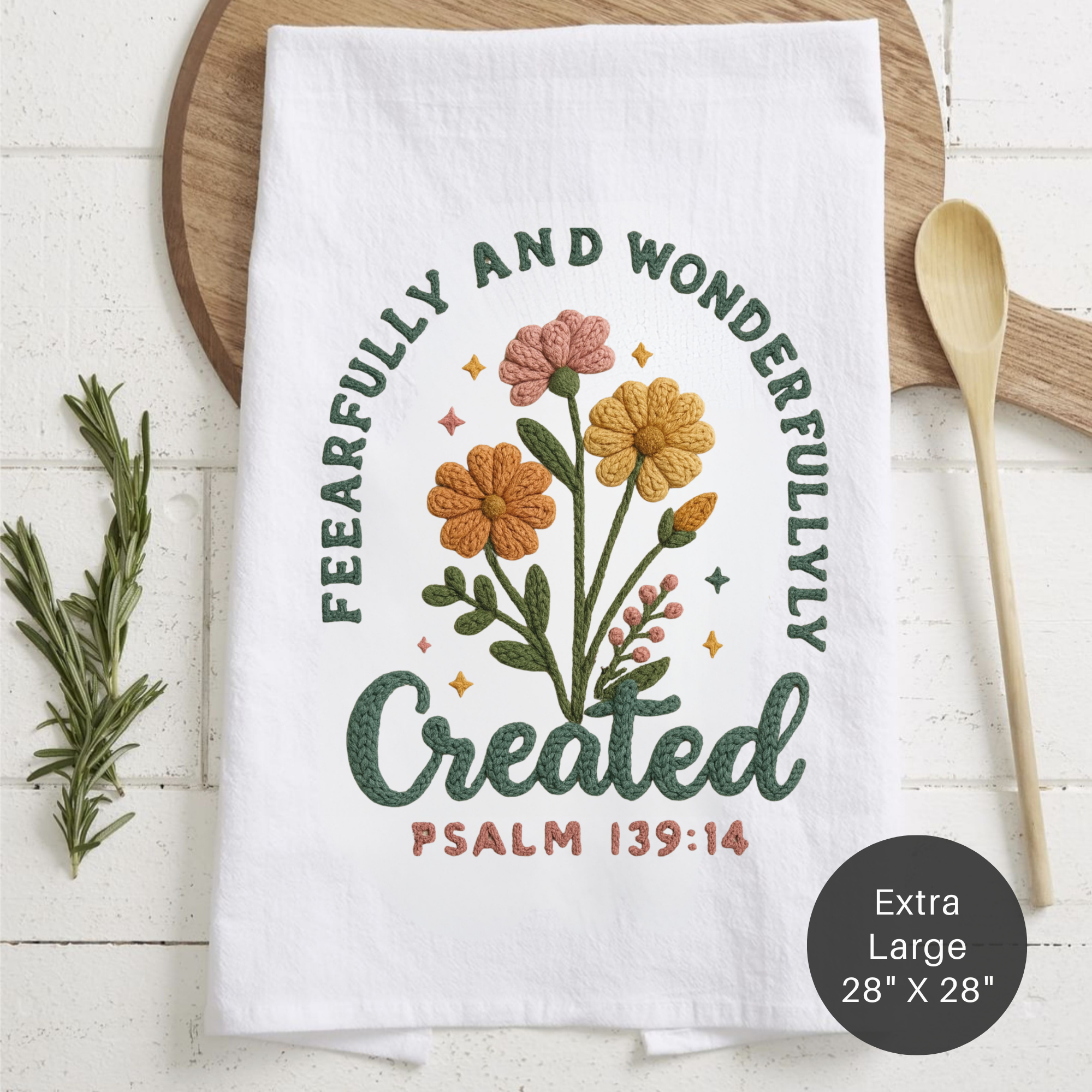 White tea towel with floral design and text on a wooden surface