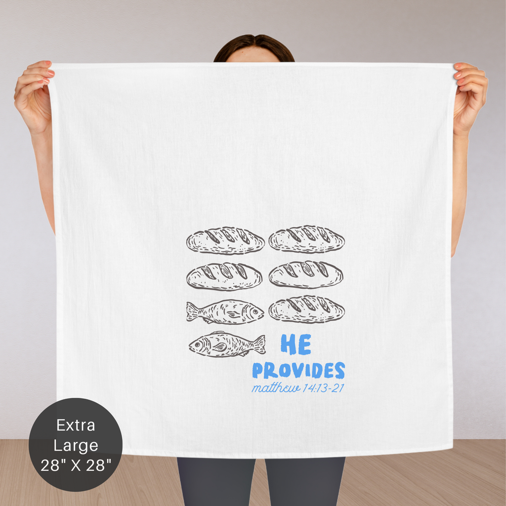 Person holding an extra large white tea towel with bread illustrations and text.