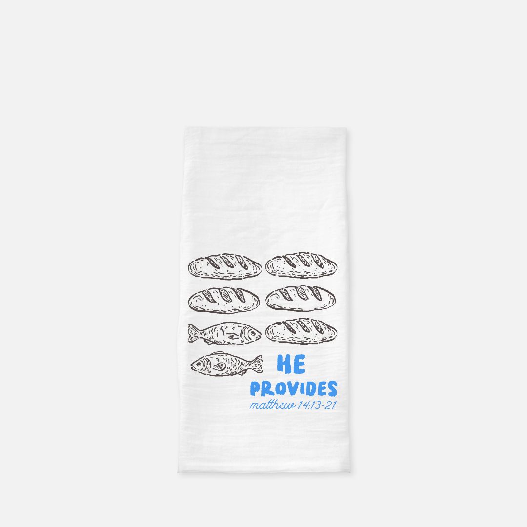 White towel with bread and fish illustrations and 'He Provides' text on a white background