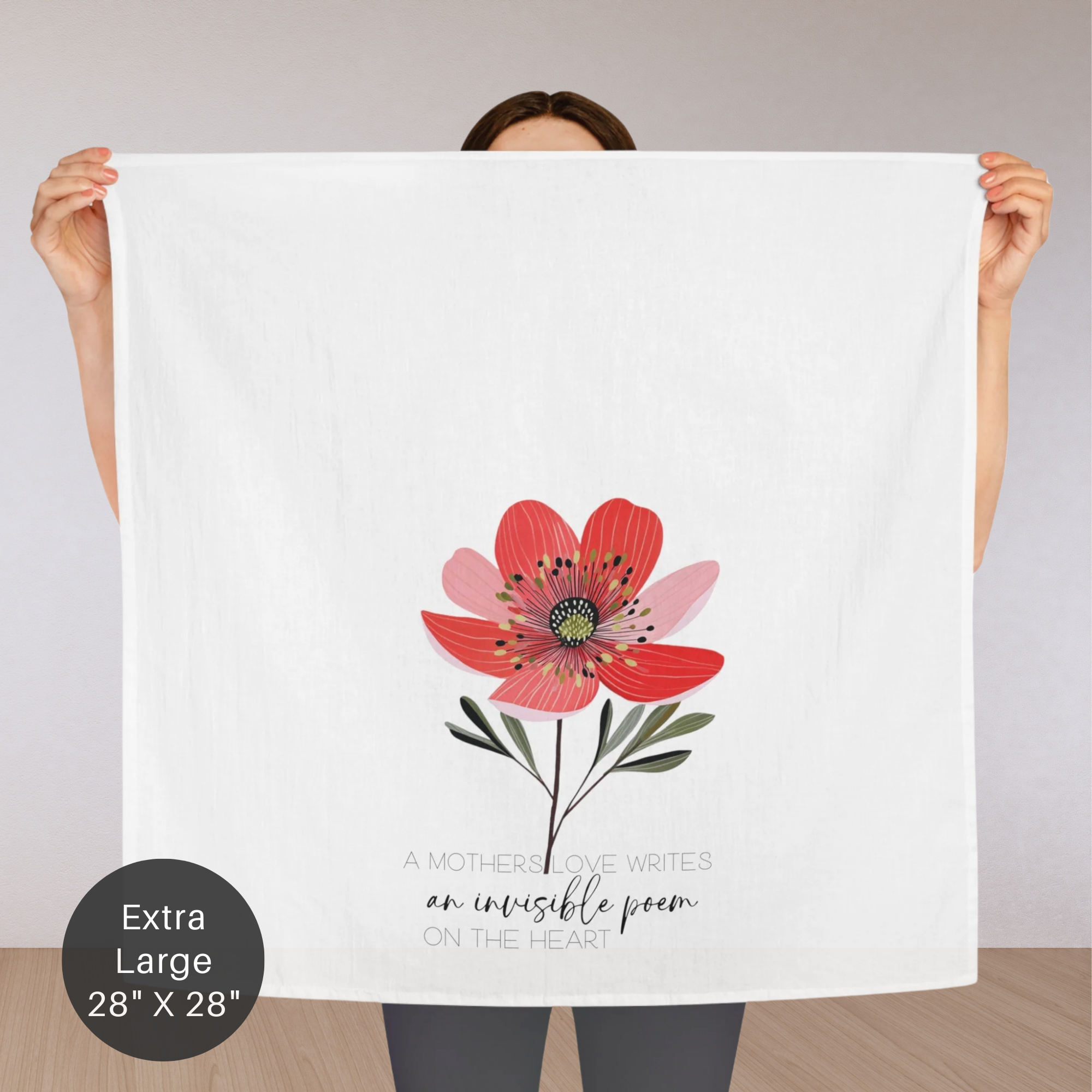 Person holding an extra large white tea towel with a red flower design and text.