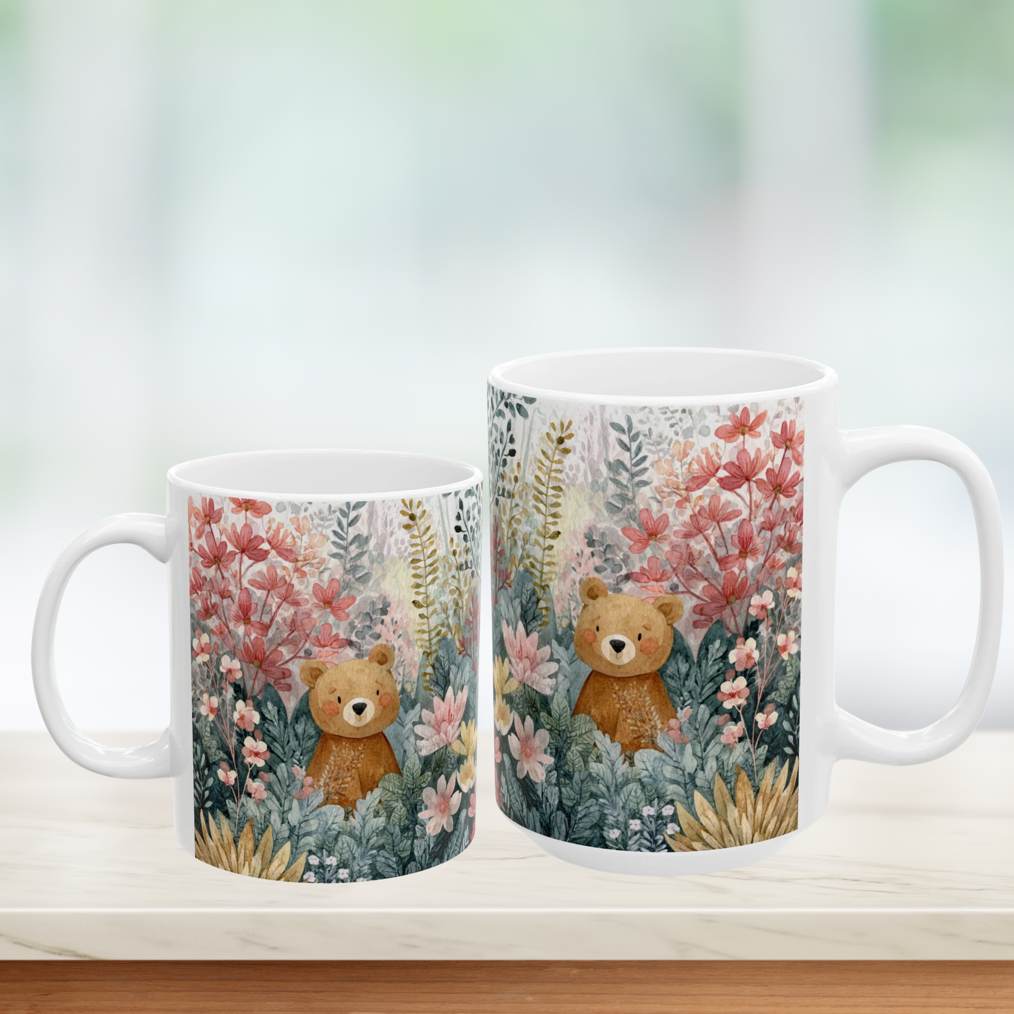 Two mugs with teddy bear and floral design on a white surface.