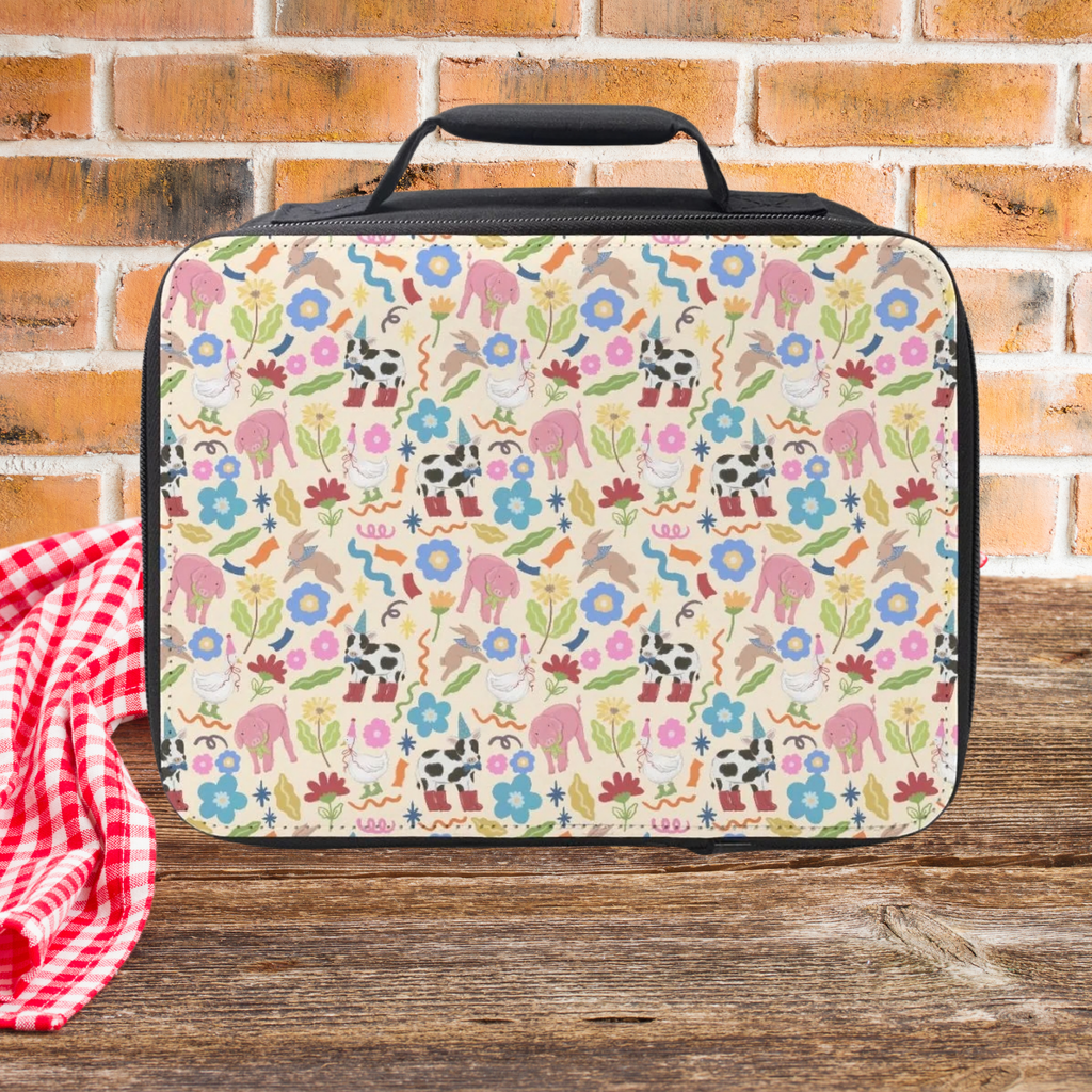 Colorful animal patterned lunch bag on a wooden picnic table with a brick wall background