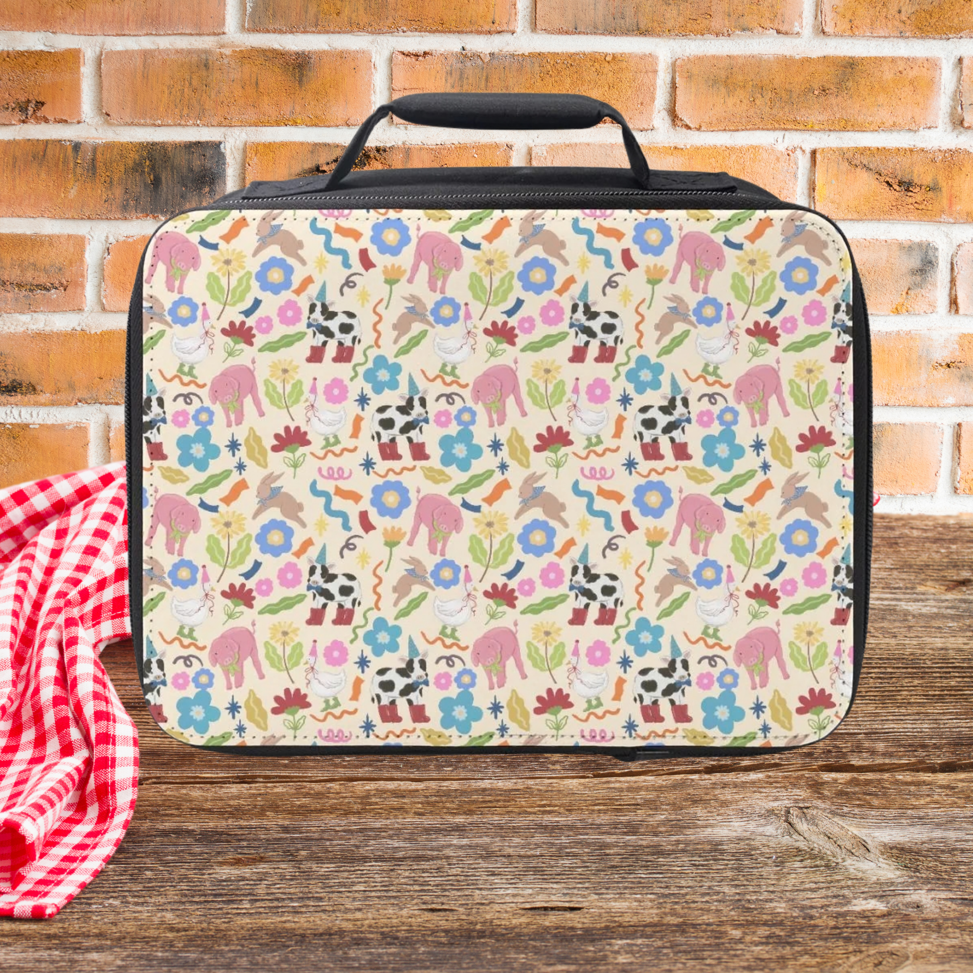 Colorful animal patterned lunch bag on a wooden picnic table with a brick wall background