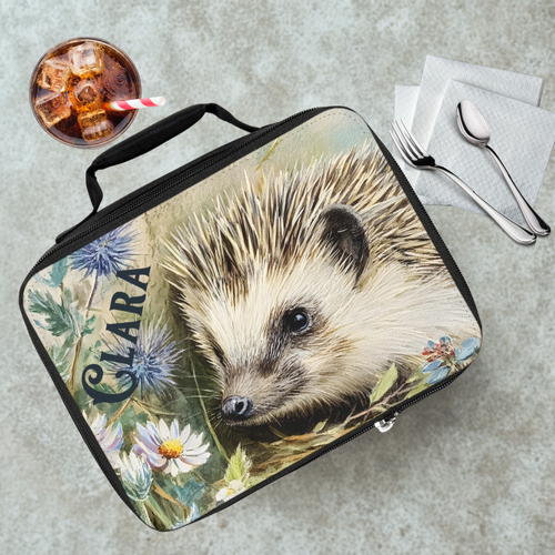 Lunch bag with a hedgehog design on a cafeteria table with a drink and utensils.