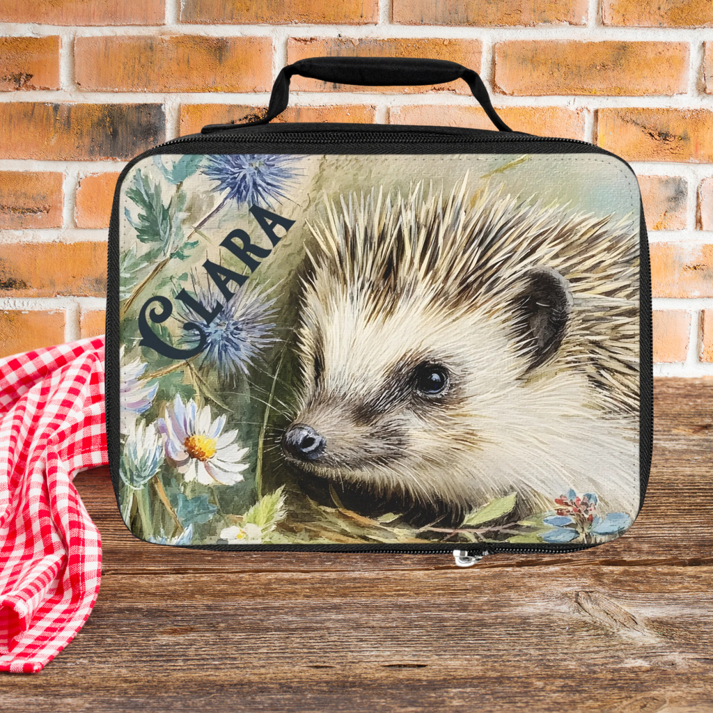  insulated lunch bag with personalized hedgehog design on a wooden picnic table with brick wall background