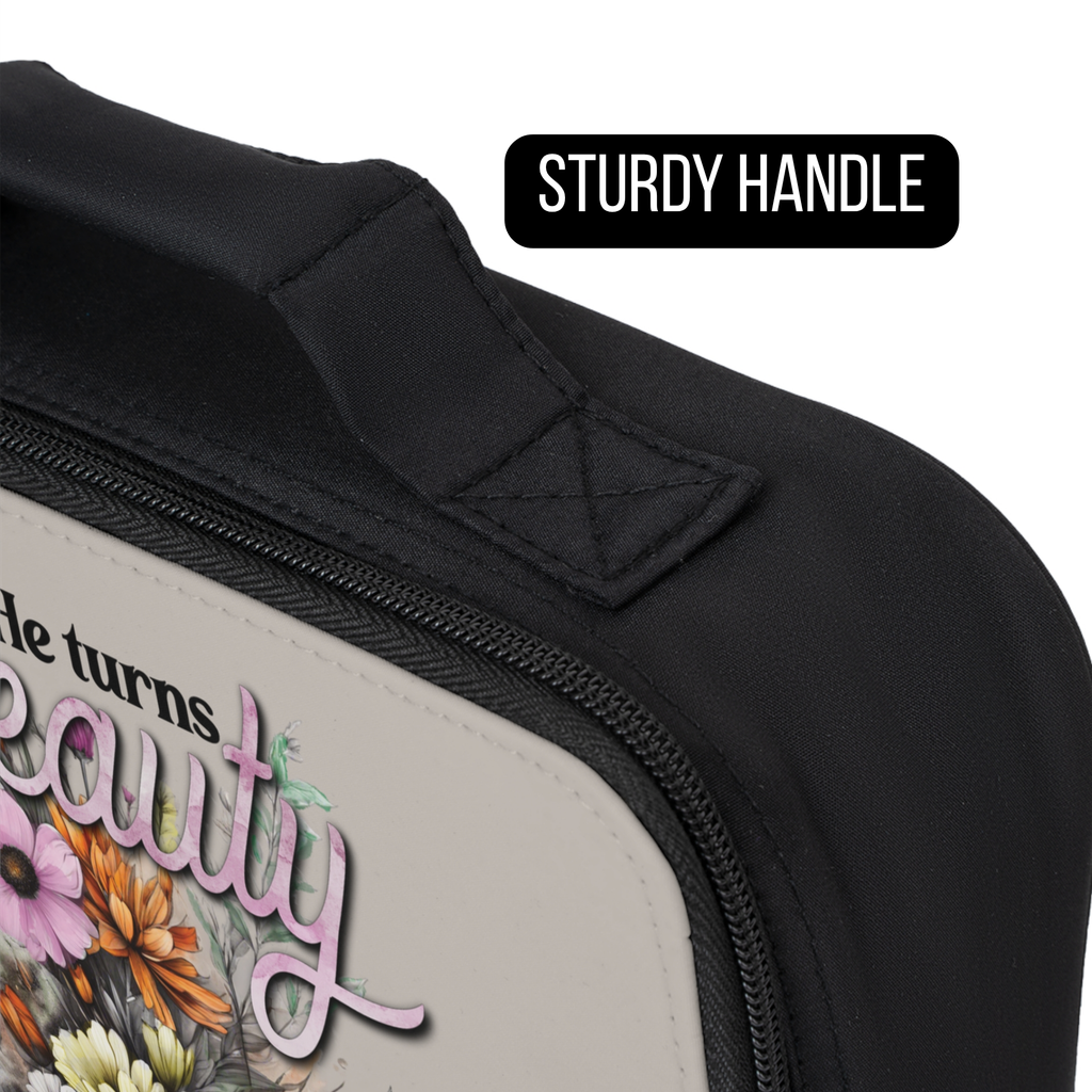 Black lunch bag with floral design and text, focusing on the sturdy handle.