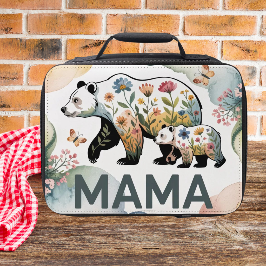 Lunch bag with floral bear design and 'MAMA' text on a wooden picnic table with brick background