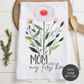 Floral tea towel with 'Mom my first home' text on a wooden surface