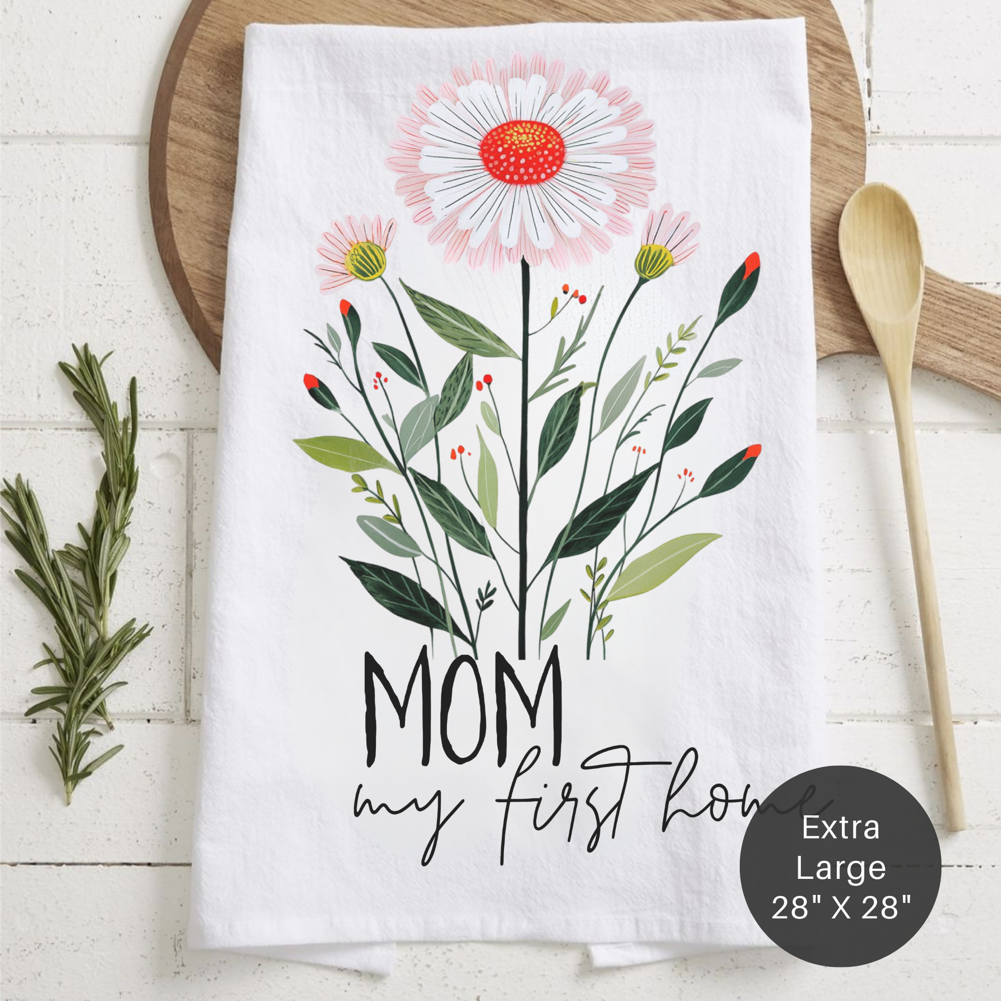 Floral tea towel with 'Mom my first home' text on a wooden surface