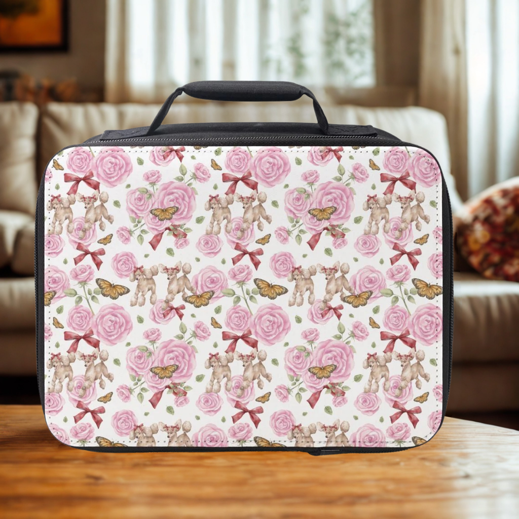 Rectangular lunch bag with poodle dogs and roses pattern on a wooden living room table.