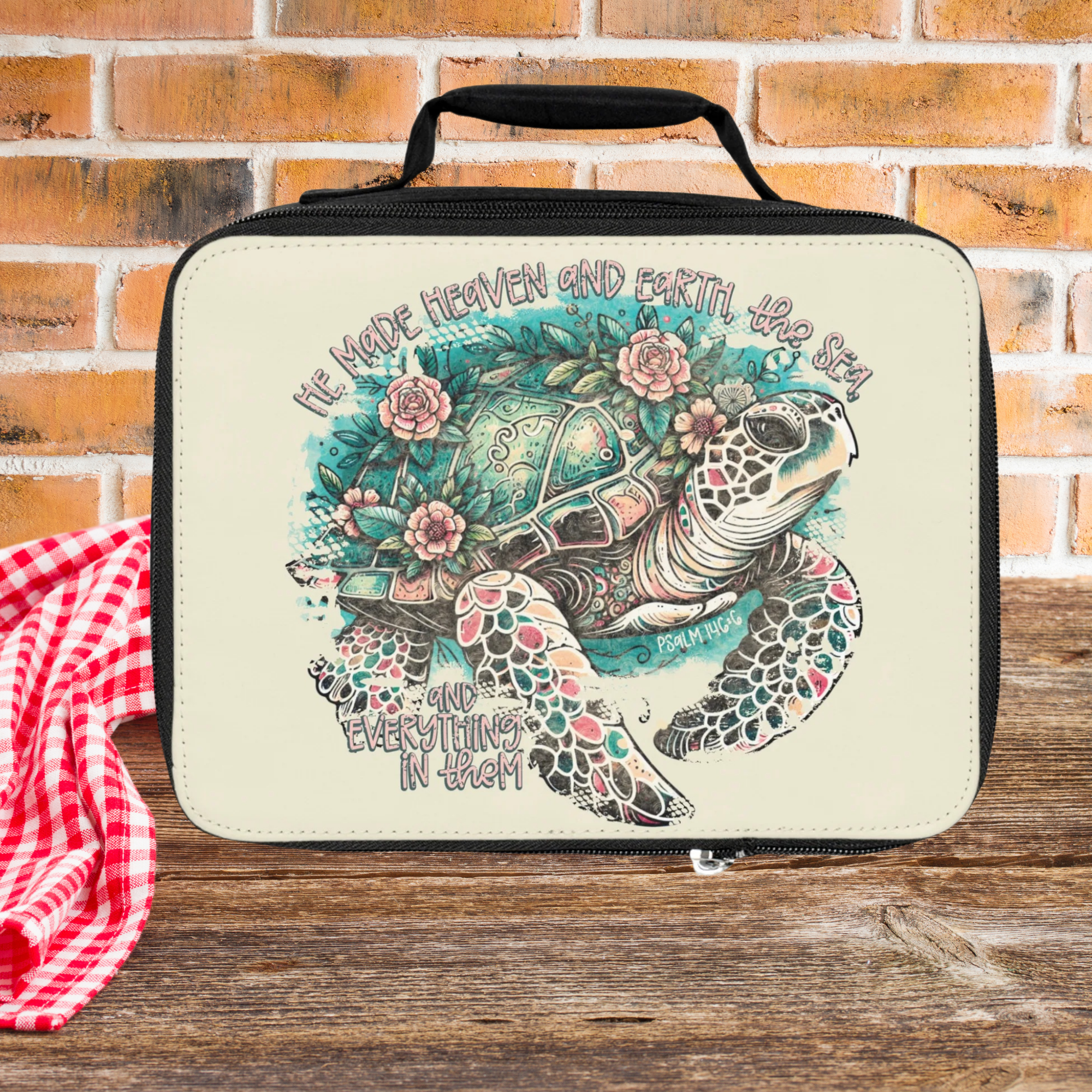  insulated lunch bag with turtle design and text on a wooden picnic table with brick background