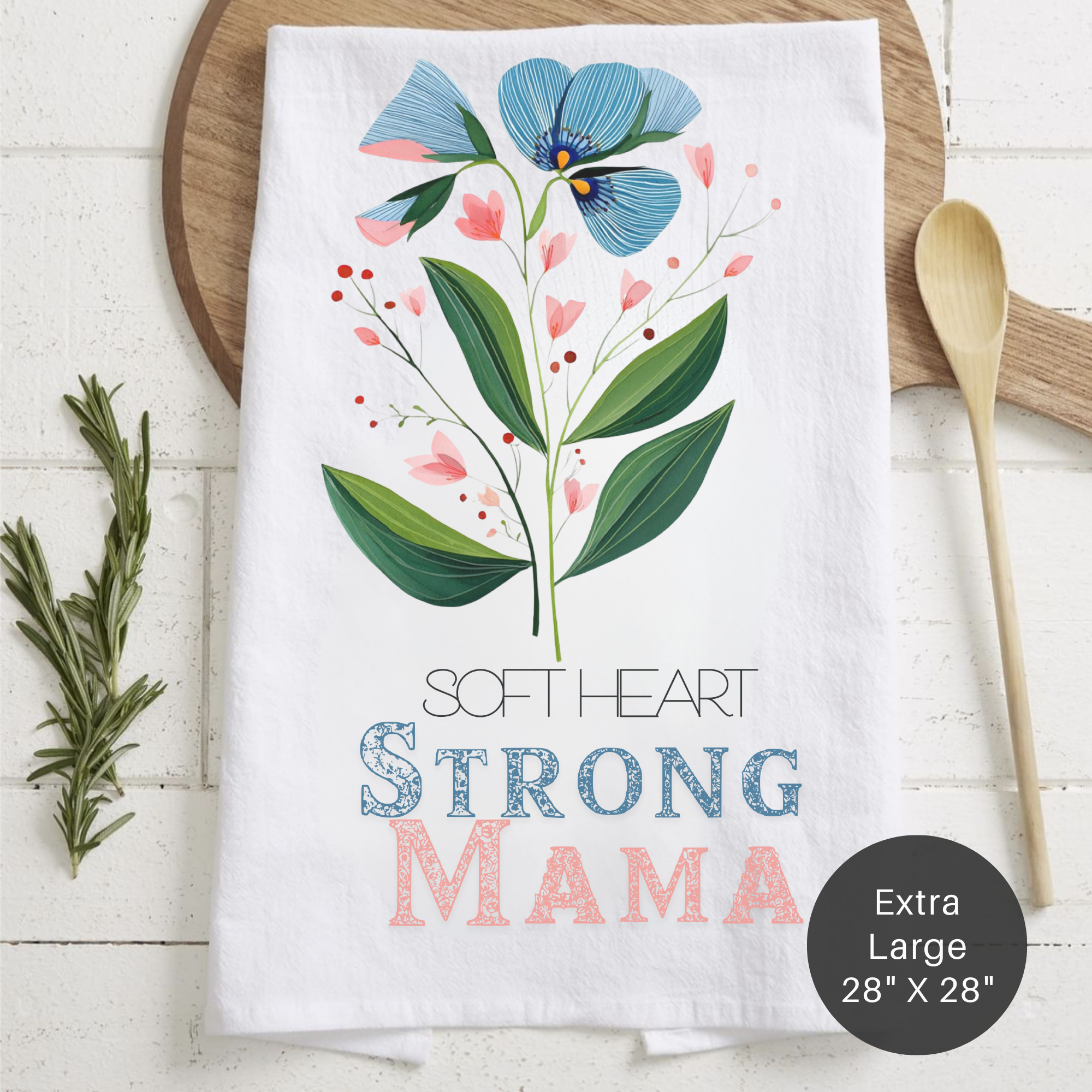 Floral-themed towel with 'Soft Heart Strong Mama' text on a wooden surface.