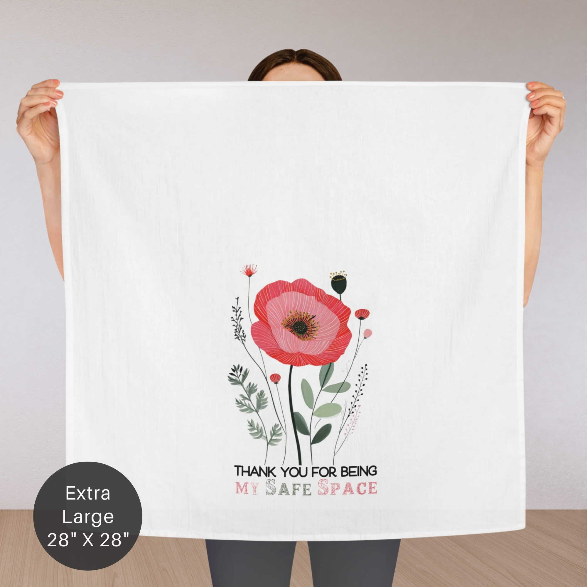 Person holding an extra large white tea towel with a floral design and text 'Thank You For Being My Safe Space'.