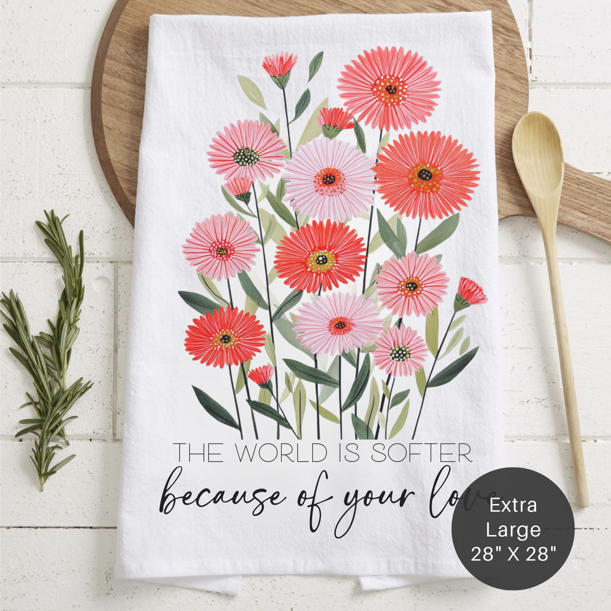 Floral towel with pink and red flowers and text on a wooden surface
