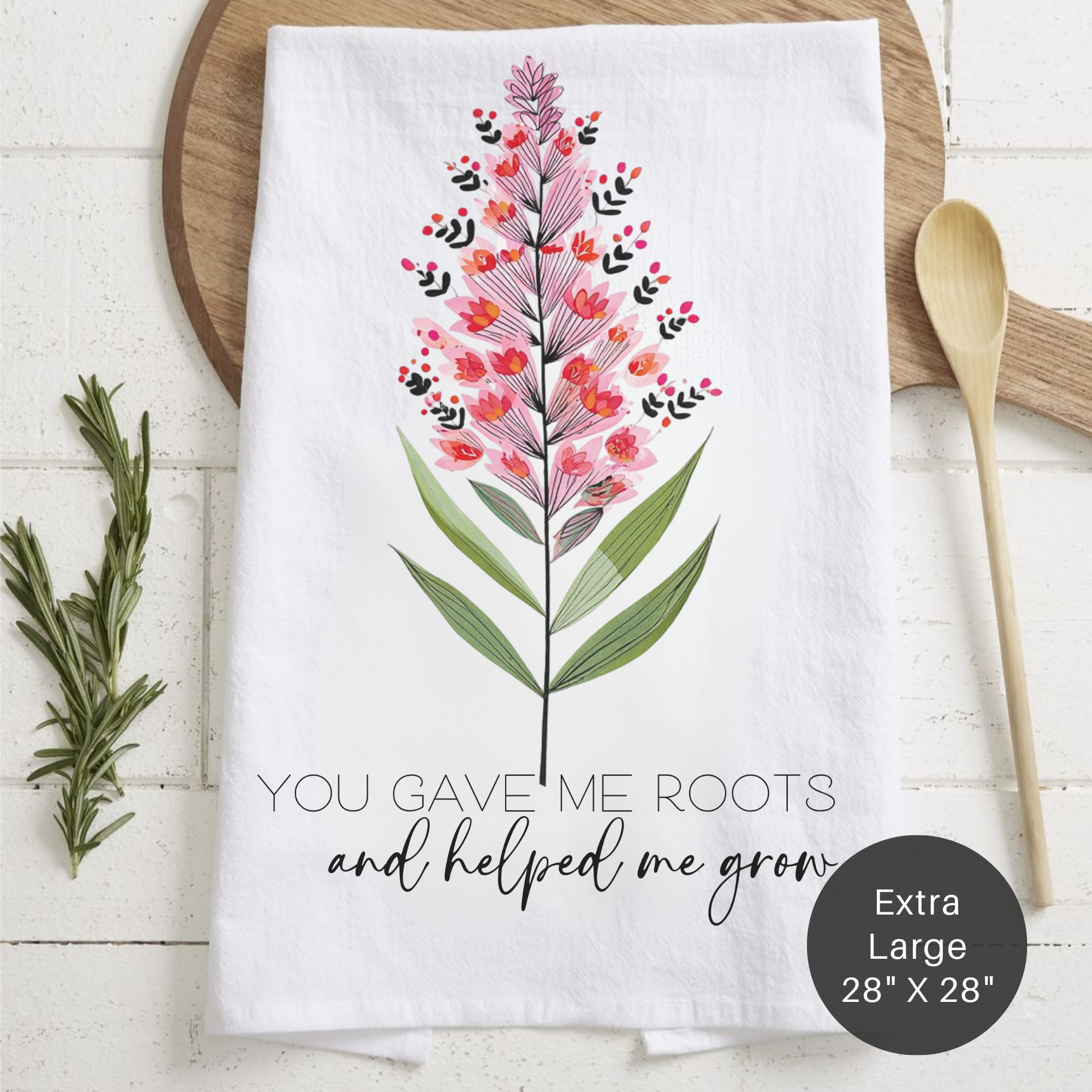 Floral design towel with text 'You Gave Me Roots And Helped Me Grow' on a wooden surface