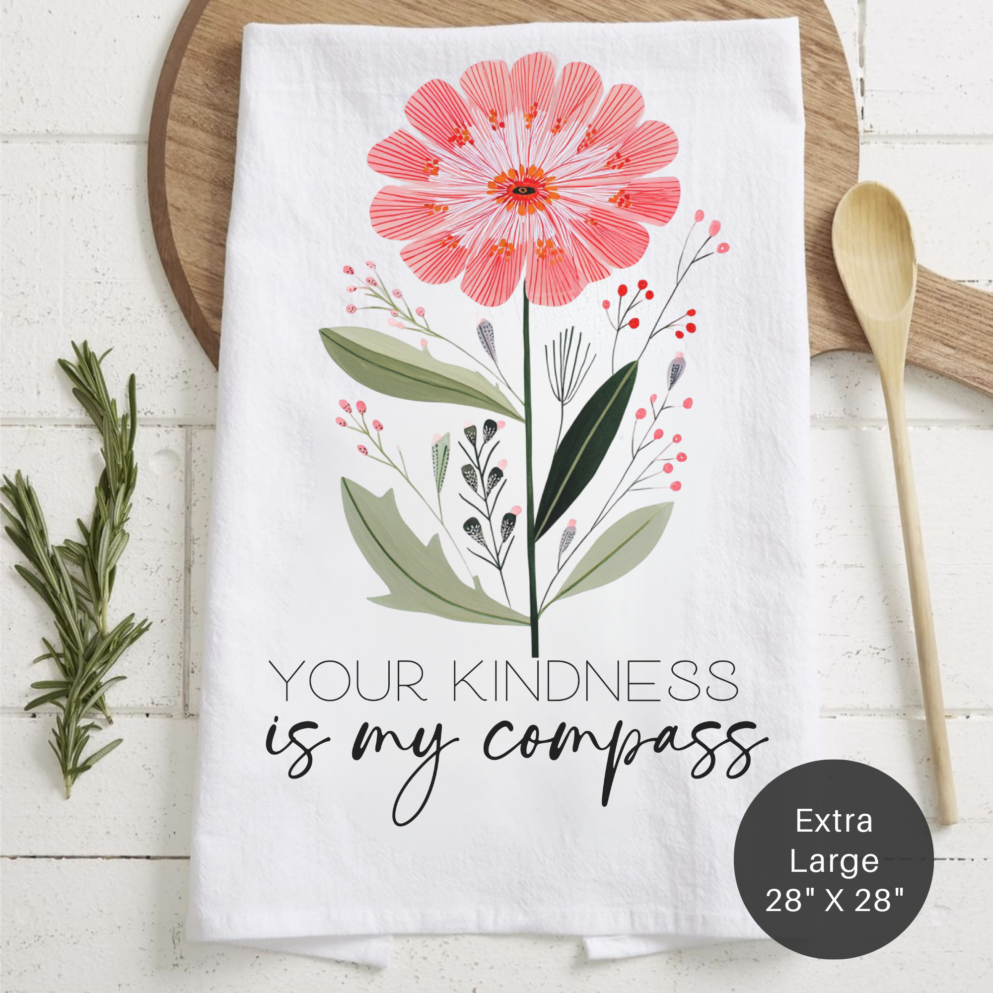 Floral-themed towel with text 'Your Kindness Is My Compass' on a wooden surface