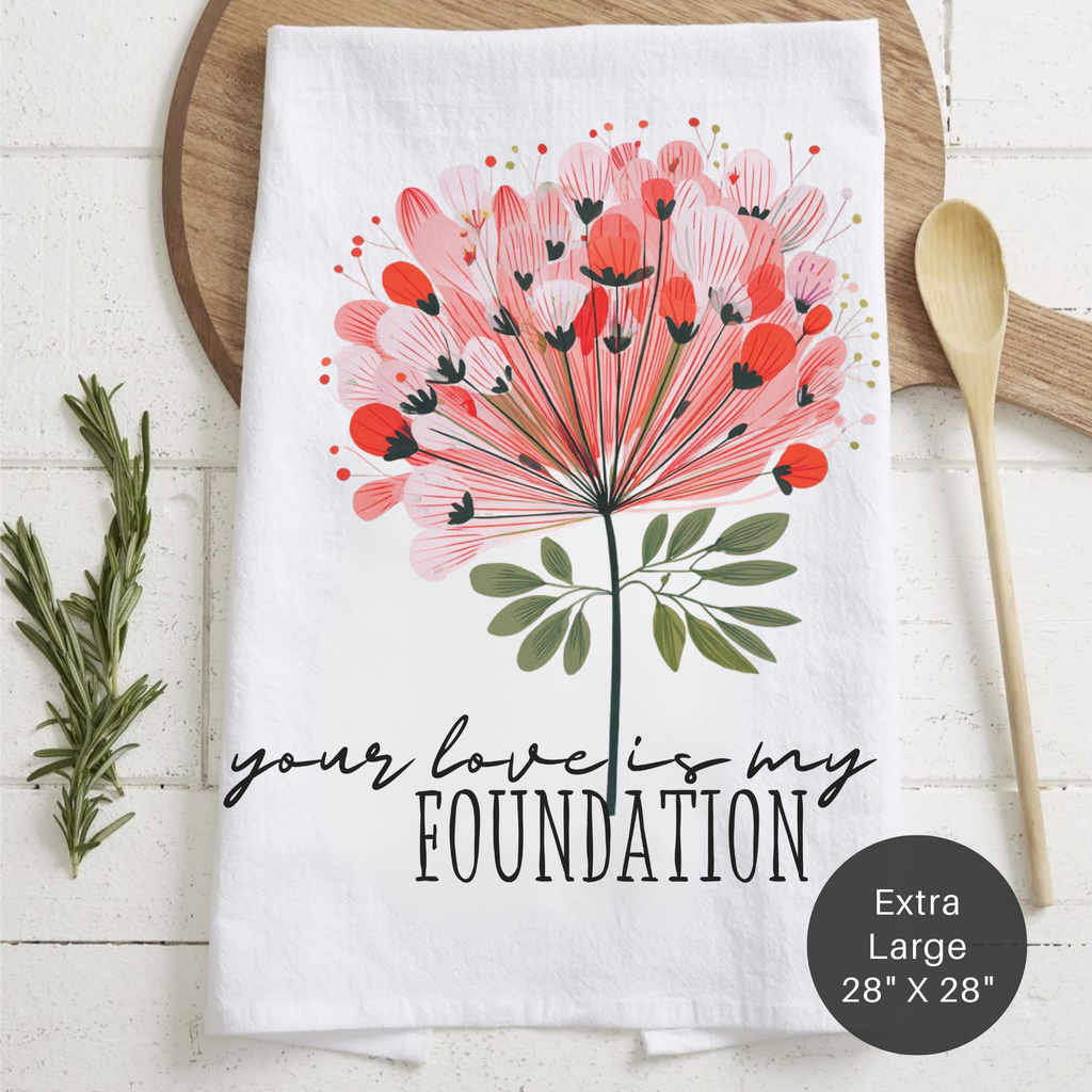 Extra large tea towel with floral design and text 'Your Love Is My Foundation' on a wooden surface