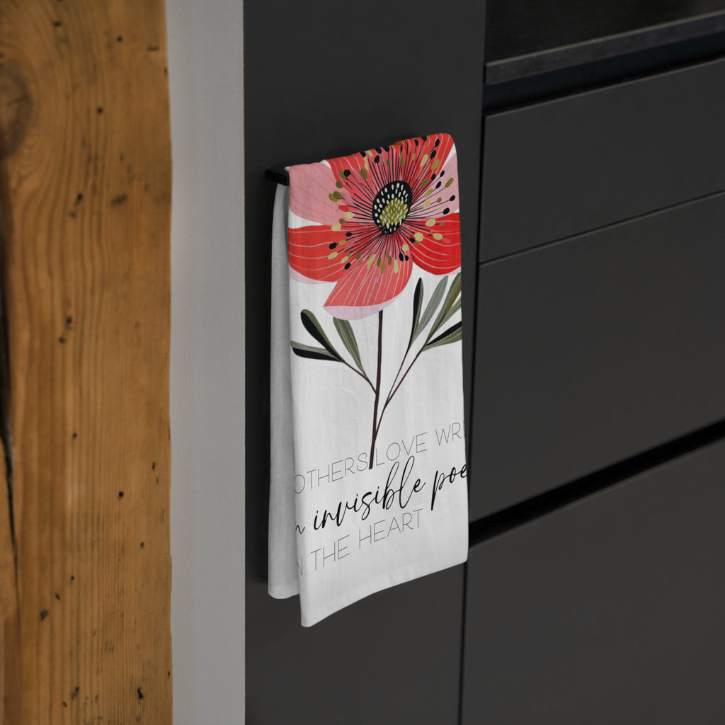 Floral-themed towel hanging on a black cabinet with wooden wall background