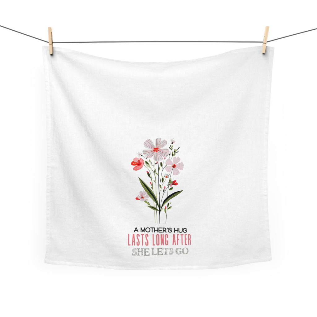 White tea towel with floral design and text hanging on a line