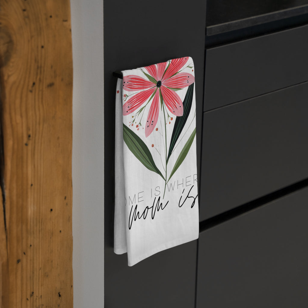 Floral tea towel with text hanging on a black cabinet.