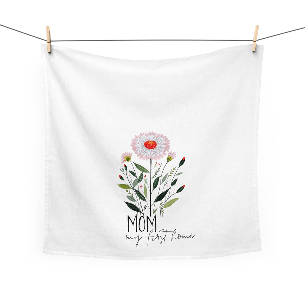 White towel with floral design and text hanging on a line